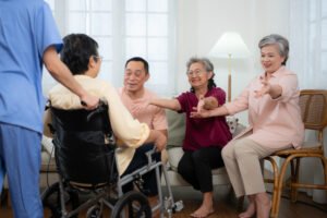 close up of senior woman in wheelchair with her caregiver in bac